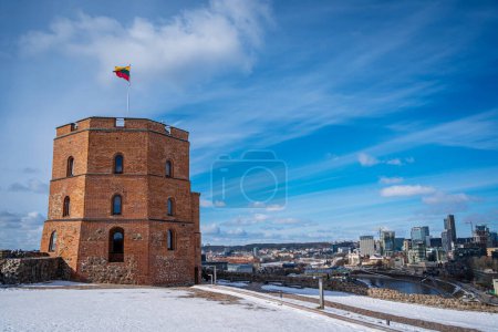 Téléchargez les photos : Drapeau lituanien agitant sur une tour du château de Gediminas contre le ciel bleu. Centre ville et belle vue sur la rivière en hiver. Vilnius, Lituanie - 9 mars 2023. - en image libre de droit