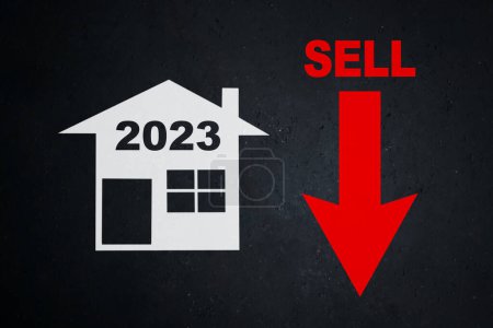 Photo for Close up of 2023 number on the house symbol with declining sell arrow in the blackboard background - Royalty Free Image