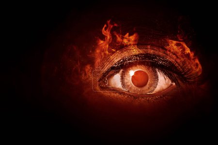 Nahaufnahme des menschlichen Auges mit Feuerflammen im dunklen Hintergrund