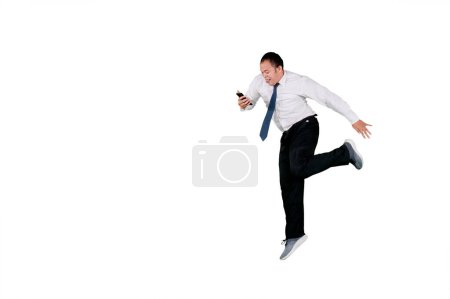 Foto de Feliz hombre de negocios recibiendo buenas noticias en el teléfono celular mientras baila con espacio de copia en el estudio. Aislado sobre fondo blanco - Imagen libre de derechos