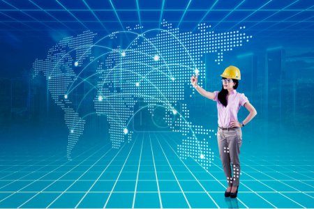 Photo for Asian woman with safety helmet with digital world map - Royalty Free Image