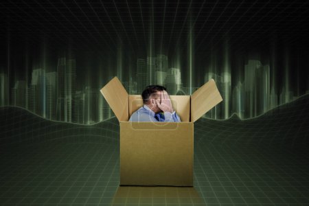 Téléchargez les photos : Homme employé se sentant triste à l'intérieur d'un carton - en image libre de droit