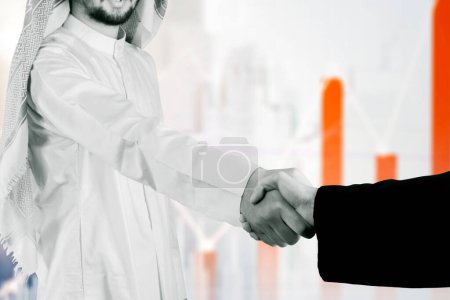 Photo for Arabian businessman handshaking with his colleague while standing - Royalty Free Image