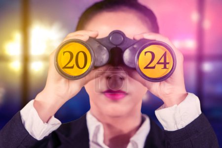 Photo for Female entrepreneur using binoculars with the 2024 new year numbers on it - Royalty Free Image