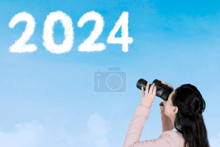 Photo for Female entrepreneur using binoculars while looking at clouds shaped 2024 numbers and upward arrow in the sky - Royalty Free Image