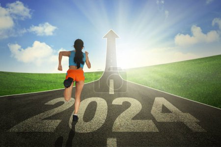 Photo for Rear view of young woman running on the road turning into an arrow rising upward with 2024 new year numbers - Royalty Free Image