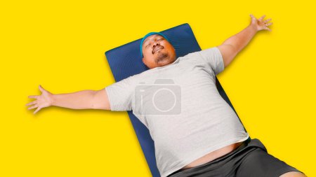 Téléchargez les photos : Vue du haut vers le bas de l'obésité homme portant des vêtements de sport tout en faisant des redressements assis sur fond blanc isolé - en image libre de droit