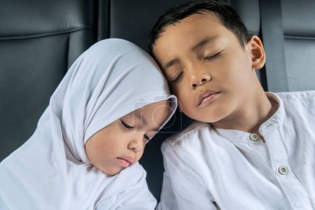 Muslim sibling children sleeping peacefully in the back seat in the car on the trip