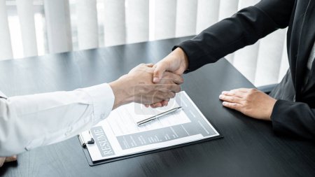 Photo for Man employer is shaking hands to congratulate the new employee after successful job interview and signing the contract in meeting room at office. - Royalty Free Image