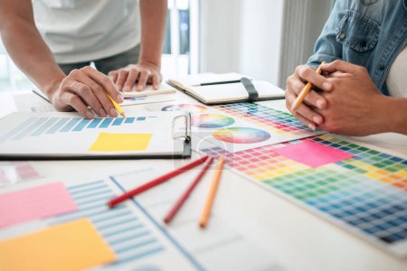 Zwei kreative Grafikdesigner arbeiten an Farbauswahl und Zeichnung auf dem Grafiktablett, Farbmusterdiagramm zur Farbauswahl als Inspiration für Kreativität am Arbeitsplatz.