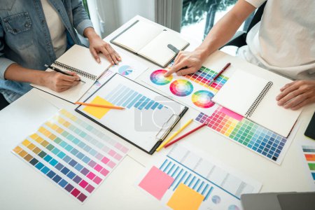 Foto de Dos equipo creativo diseñador gráfico que trabaja en la selección de color y dibujo en la tableta gráfica, muestras de muestra de color gráfico para colorear selección en inspiración para la creatividad en el lugar de trabajo. - Imagen libre de derechos