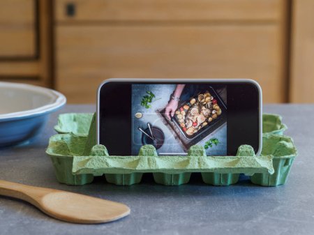Foto de Soporte para smartphone DIY fabricado en cartón de huevo. Receta para cocinar. Hackeos de cocina. - Imagen libre de derechos