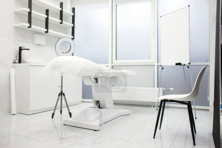 Photo for Empty white beautician office. medical room with modern cosmetology equipment and a couch in the clinic, the interior of a new cosmetology room without people - Royalty Free Image