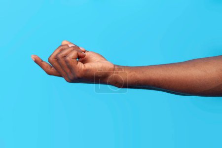 Photo for Come here. african american male hand calls and beckons on blue isolated background, close-up - Royalty Free Image