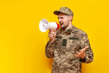 Ukrainian army soldier in pixel military camouflage uniform announces information into a megaphone and shouts on a yellow isolated background, Ukrainian military cadet speaks and warns into a