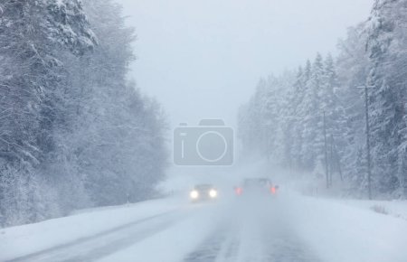 Photo for Cars in heavy snowstorm with weak visibility - Royalty Free Image