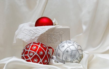 Foto de Bolas de Navidad rojas y plateadas con fondo textil brillante - Imagen libre de derechos