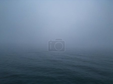 Téléchargez les photos : Atmosphère d'une mer la nuit et le brouillard. La combinaison du cadre sombre et des conditions brumeuses peut créer un environnement étrange et mystérieux qui peut être troublant ou fascinant à observer.. - en image libre de droit
