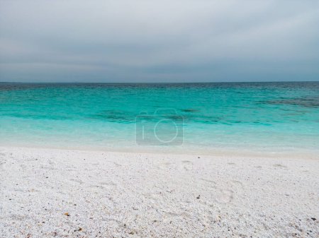 Foto de La playa con guijarros de mármol blanco y mar turquesa en la isla griega de Tasos es una maravilla natural impresionante. Vista aérea. El contraste de los guijarros blancos prístinos contra el azul vivo - Imagen libre de derechos