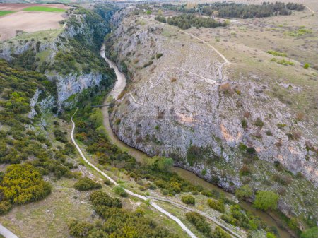 Aerial top view of the Aggitis canyon in Greece offers a breathtaking aerial view of the winding river, steep cliffs, and lush vegetation that make up this natural wonder.