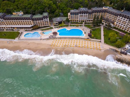 Foto de Una vista aérea impresionante de un hotel de lujo con una piscina frente al mar, listo para dar la bienvenida a los huéspedes al comienzo de la temporada. - Imagen libre de derechos