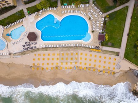 Foto de Una vista aérea impresionante de un hotel de lujo con una piscina frente al mar, listo para dar la bienvenida a los huéspedes al comienzo de la temporada. - Imagen libre de derechos
