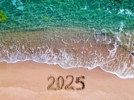 2025 year drawing on sandy beach sea at sunny day