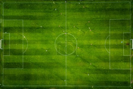 Vista aérea de un campo de fútbol en acción, con jugadores corriendo, pasando y anotando goles