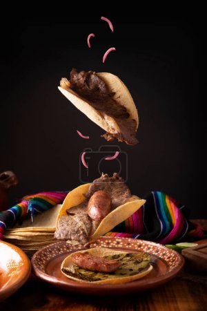 Carne Asada Tacos cayendo. (carne asada) plato muy popular en el norte de México, también llamado Asado, Discada o Parrillada, es una técnica de cocción en la que la comida se expone al calor de las brasas.