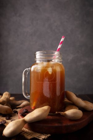 Photo for Tamarind Water, called Agua de Tamarindo, is one of the traditional "Aguas Frescas" in Mexico. Infused drink made with tamarind to which beneficial health properties are attributed. - Royalty Free Image