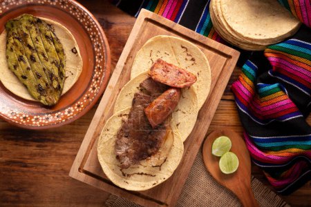Téléchargez les photos : Tacos à la viande rôtie avec Chorizo. Plat très populaire dans le nord du Mexique, également appelé Carne Asada, Asado, Discada ou Parrillada, est une technique de cuisson dans laquelle la nourriture est exposée à la chaleur des braises. - en image libre de droit