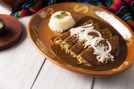 Photo for Enchiladas de Mole. Also known as mole poblano enchiladas, they are a typical Mexican dish that is very popular in Mexico and the rest of the world. - Royalty Free Image