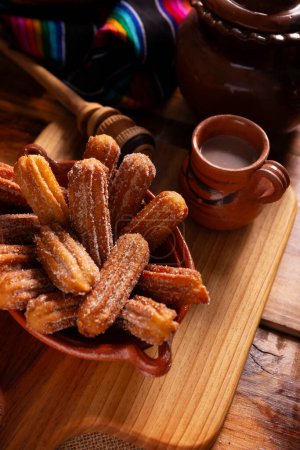 Photo for Churros. Fried wheat flour dough, a very popular sweet snack in Spain, Mexico and other countries where it is customary to eat them for breakfast or snack accompanied by hot chocolate or coffee. - Royalty Free Image