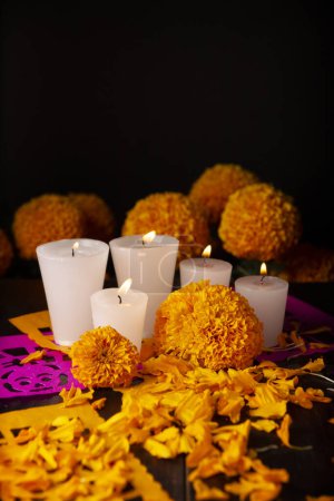 Foto de Velas con flores de color naranja Cempasuchil o caléndula. (Tagetes erecta) y Papel Picado. Decoración tradicionalmente utilizada en altares para la celebración del día de los muertos en México - Imagen libre de derechos