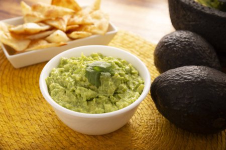 Photo for Guacamole. Avocado dip sauce, one of its many ways of consuming it is spread on tortilla chips also called Nachos. Mexican easy homemade sauce recipe very popular. - Royalty Free Image
