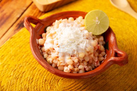 Esquites. Maiskerne gekocht und serviert mit Mayo, saurer Sahne, Zitronen- und Chilipulver, sehr beliebtes Street Food in Mexiko, auch als Elote en Vaso bekannt. Das Rezept variiert je nach Region.