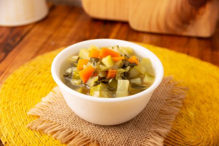 Photo for Homemade fresh vegetable soup, easy recipe made with chopped vegetables, carrot, celery, pumpkin, spinach, chayote and other ingredients, healthy dish popular in many countries. - Royalty Free Image