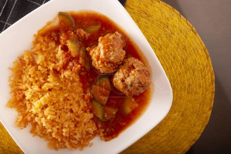 Photo for Meatballs with red rice. In Mexico they are known as Albondigas, served with vegetables in a light tomato sauce called Caldillo. Very popular recipe for homemade food in Mexico. - Royalty Free Image