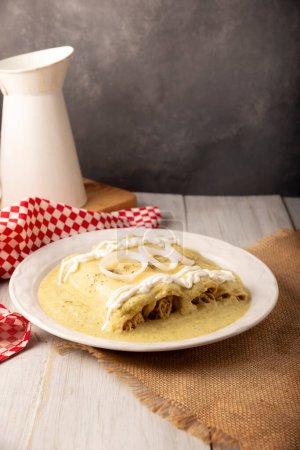 Photo for Mexican food. Enchiladas with creamy green sauce filled with shredded chicken meat and covered with melted cheese, in Mexico they are called Swiss Enchiladas. Very popular recipe in Mexican cuisine. - Royalty Free Image