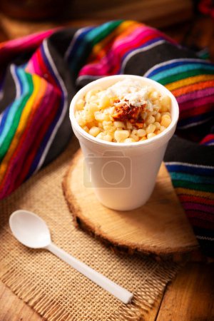 Photo for Esquites. Corn kernels cooked and served with mayo, sour cream, lemon and chili powder, very popular street food in Mexico, also known as Elote en Vaso. The recipe varies depending on the region. - Royalty Free Image