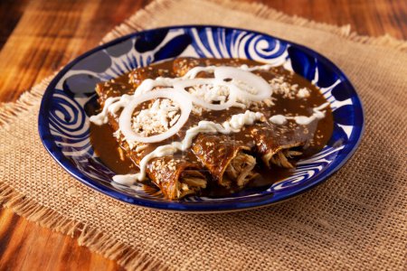 Photo for Chicken enmoladas. Also known as mole poblano enchiladas, they are a typical Mexican dish that is very popular in Mexico and the rest of the world. - Royalty Free Image