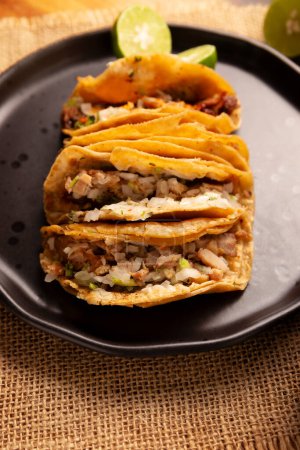 Suadero Tacos. Viande hachée frite dans une mini tortilla de maïs. Street food de CDMX, Mexique, traditionnellement accompagné de coriandre, d'oignon et de sauce rouge épicée.