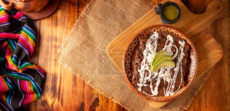 Enfrijoladas. Mais-Tortillas in Bohnensauce getaucht, mit Sahne und Käse bedeckt, können sie bedeckt oder mit Hühnerfleisch, Käse oder einer anderen Zutat gefüllt werden. Traditionelles mexikanisches Gericht.