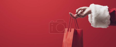 Compras y venta de Navidad: Santa Claus sosteniendo una bolsa roja