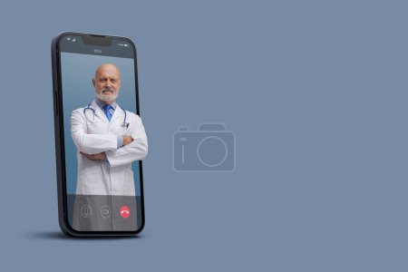 Téléchargez les photos : Médecin professionnel dans un vidéocall smartphone et souriant, médecin en ligne et concept de service de télémédecine - en image libre de droit