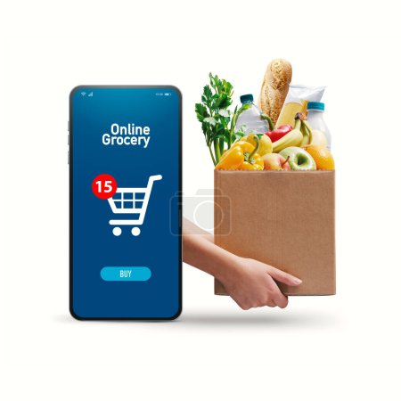 Foto de Manos sosteniendo una caja llena de alimentos frescos y aplicación de compras en línea en el teléfono inteligente - Imagen libre de derechos