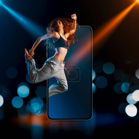 Photo for Professional dancer jumping out of a smartphone screen and stage lights in the background: entertainment and apps concept - Royalty Free Image
