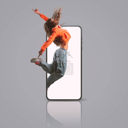 Foto de Professional dancer jumping out of a smartphone screen, mobile apps and dance concept, copy space - Imagen libre de derechos