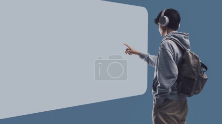 Téléchargez les photos : Adolescent interagissant avec un tableau blanc à écran tactile, concept d'apprentissage et de technologie en ligne, espace de copie vierge - en image libre de droit
