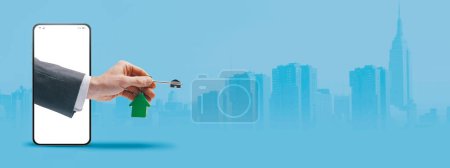 Téléchargez les photos : Agent immobilier main dans la main dans un écran de smartphone tenant vos nouvelles clés de maison, concept d'application immobilière, espace de copie - en image libre de droit